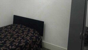 A bedroom with a bed, a wardrobe, and a hanging light fixture. - Charming 2-bed Apartment in Wolverhampton (Wolverhampton)