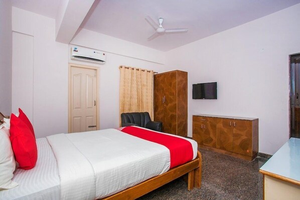 Une chambre à coucher comprenant un lit, une armoire, un téléviseur et un appareil de climatisation.