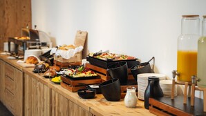 A buffet setup with various food items and beverages.