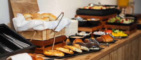 A buffet with various food items including pastries, fruits, and vegetables.