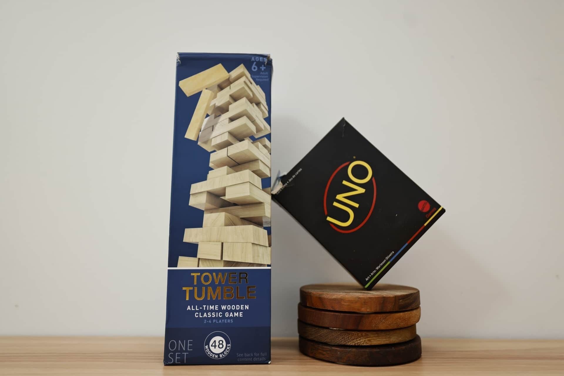 Caja del juego Torre Tumbling y sus fichas sobre un posavasos de madera.