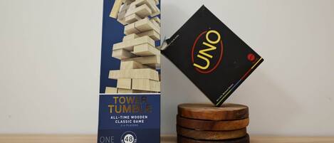 Caja del juego Torre Tumbling y sus fichas sobre un posavasos de madera.
