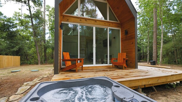 A wooden cabin with a hot tub and two chairs outside. - Luxury Cabin - Riolago (Montgomery County)