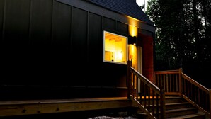 Eine Holzhütte mit Veranda und einer Treppe, die zu einer Tür führt.