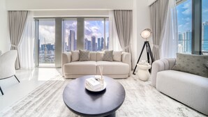 A modern living room with a large window offering a city view, a round coffee table, and a sofa.