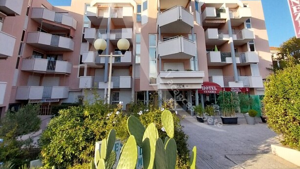 A multi-story hotel with balconies, a central entrance, and a sign indicating it is the Hotel Venezia. - STUDIO DANS RESIDENCE AVEC ASCENSEUR, PLAGE A PIED (Sète)