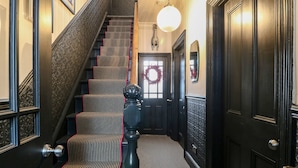 Un escalier recouvert d’une moquette à rayures et orné d’une balustrade décorative.