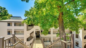 A multi-story building with a central staircase, surrounded by trees.