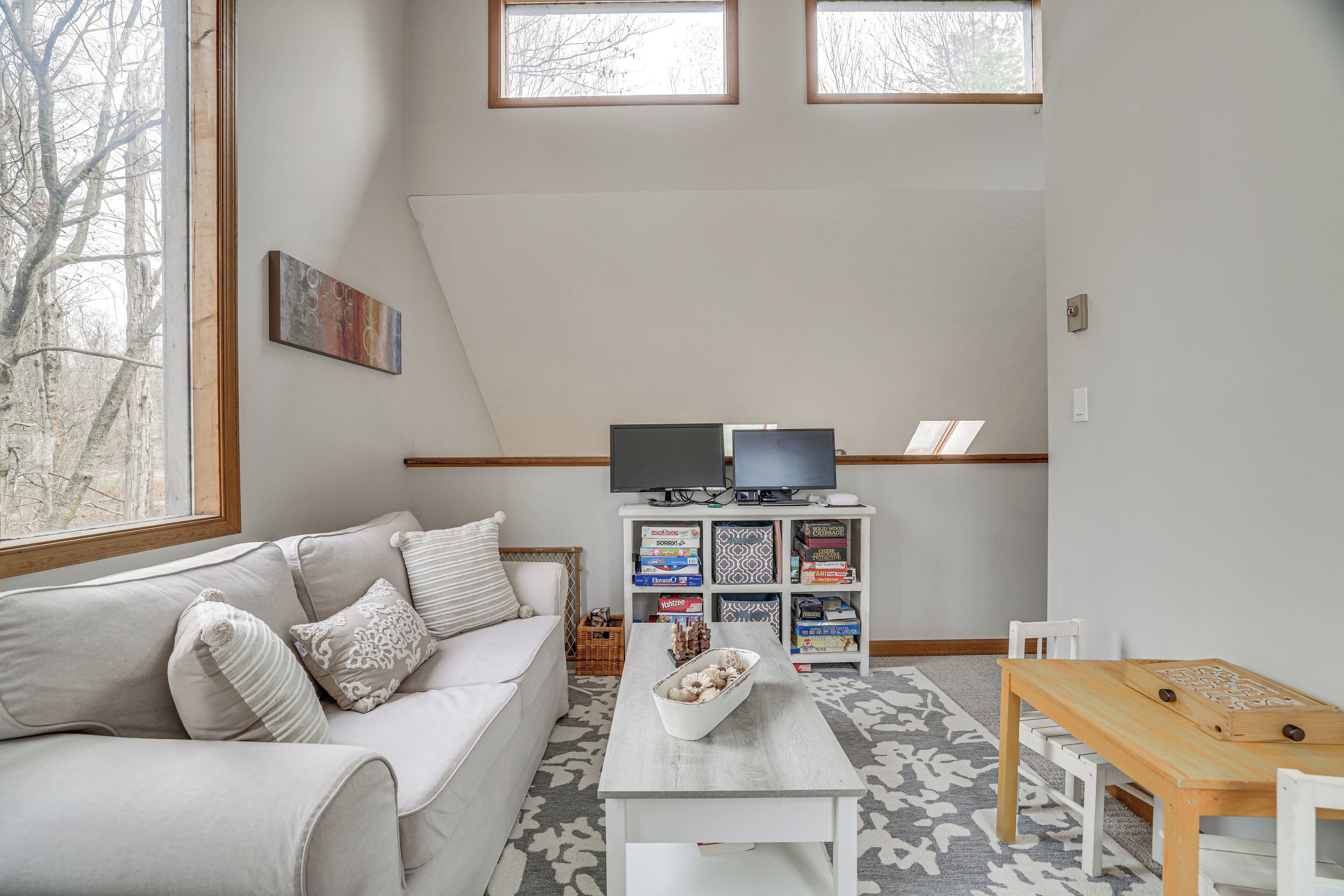 A living room with a sofa, a coffee table, a TV, and a bookshelf.