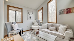 A living room with a grey and white sofa set, a wooden coffee table, and a chessboard. - Pocono Pines Home w/ Private Hot Tub! (Pocono Pines)