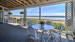 Un espace extérieur aménagé, abrité et doté de sièges, offrant une vue sur la plage.