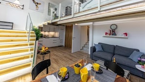 Un appartement moderne comprenant un coin repas, une cuisine, un salon et un balcon.