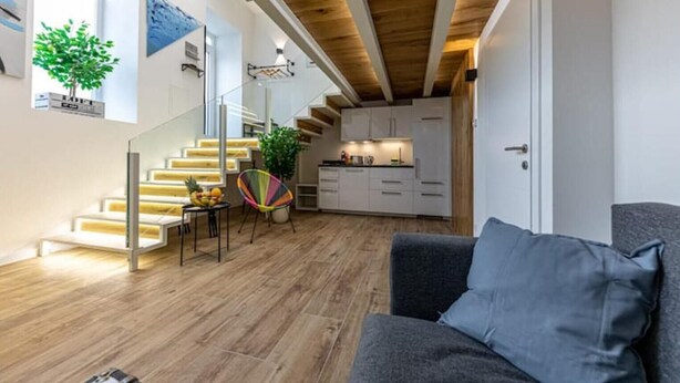 Un espace de vie moderne comprenant un escalier, un coin repas et une cuisine.