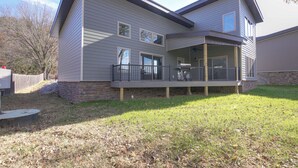 A two-story house with a covered porch and a stone foundation. - Pet-friendly Cotter Retreat w/ Deck & Gas Grill! (Cotter)