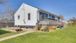 A single-story house with a front porch, a small garden, and a clear blue sky. - Pet-friendly Hiawatha Retreat w/ Private Yard! (Hiawatha)