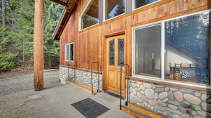 A wooden cabin with a stone foundation, large windows, and a covered porch. - 3 Mi to Lake Easton Sno-park: Family Cabin Escape! (Easton)