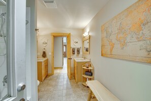 A bathroom with a large world map, wooden cabinets, a bench, and a shower area.