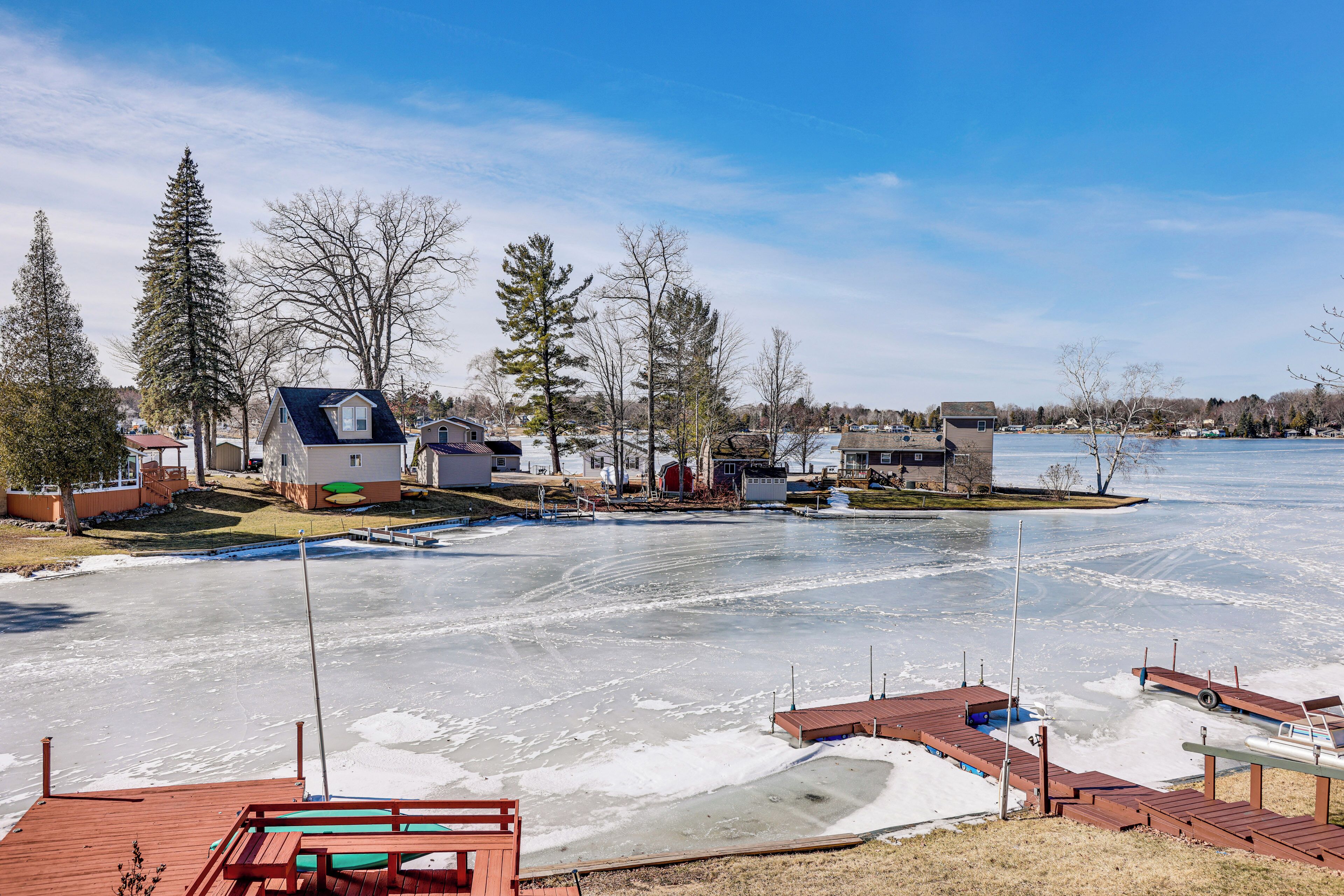A residential area with houses, a dock, and a frozen lake.