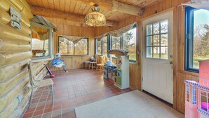 A log cabin interior with a dining area, wooden walls, and large windows. - Secluded Log Cabin < 1 Mi to Munger State Trail! (Finlayson)