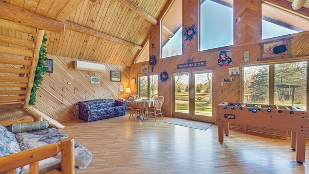 A spacious wooden interior with a sofa, dining table, and foosball table. - Secluded Log Cabin < 1 Mi to Munger State Trail! (Finlayson)