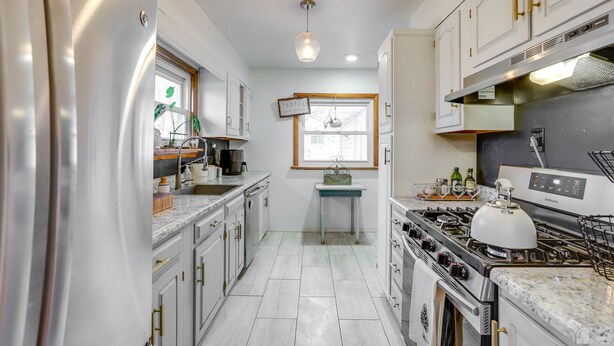 A modern kitchen with white cabinets, stainless steel appliances, and a central island. - Charming Arnold Home w/ Patio & Chicken Coop! (Arnold)