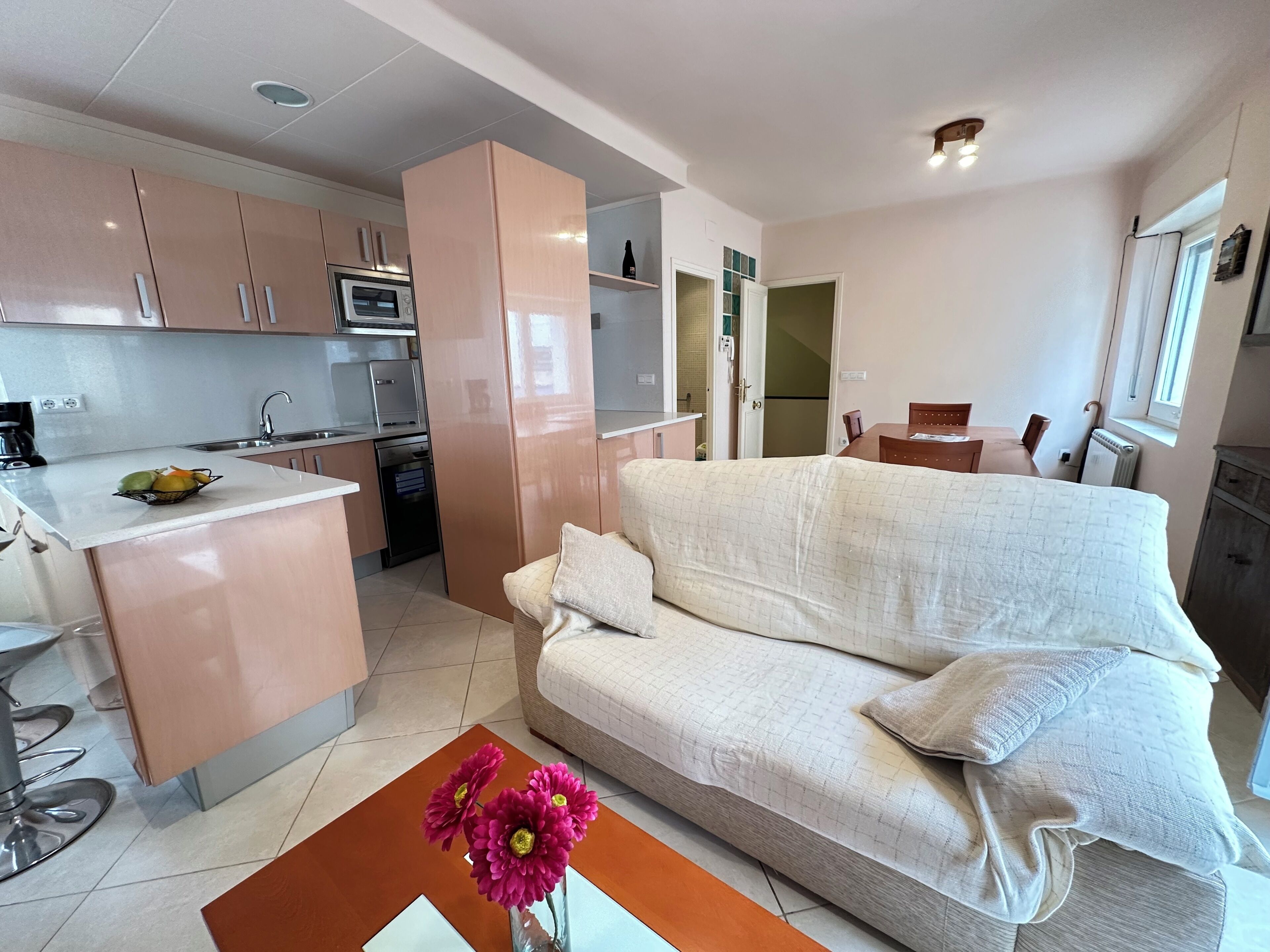 A compact living space with a kitchenette, a sofa, and a coffee table.