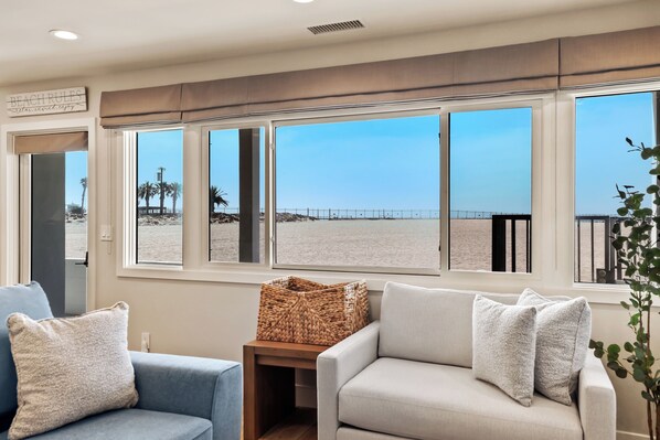 Una habitación con vista a la playa, un sofá, una mesita y una cesta.