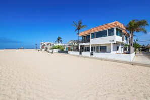 A beachfront property with a two-story building, a visible address number, and a sandy beach in the background. - ON THE SAND! Beachfront Seal Beach CA 3bd 3ba home (Seal Beach)