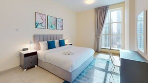 A modern bedroom with a bed, bedside tables, a desk, and a window with curtains. - Neat 2 Bed l Media City Park l near Dubai Harbour (Dubai Marina)