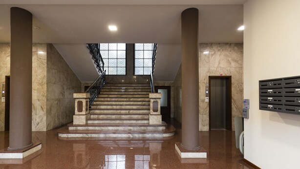 A spacious lobby with a marble staircase, a reception desk, and a mail drop area. - notaMi - Little West (Milan)