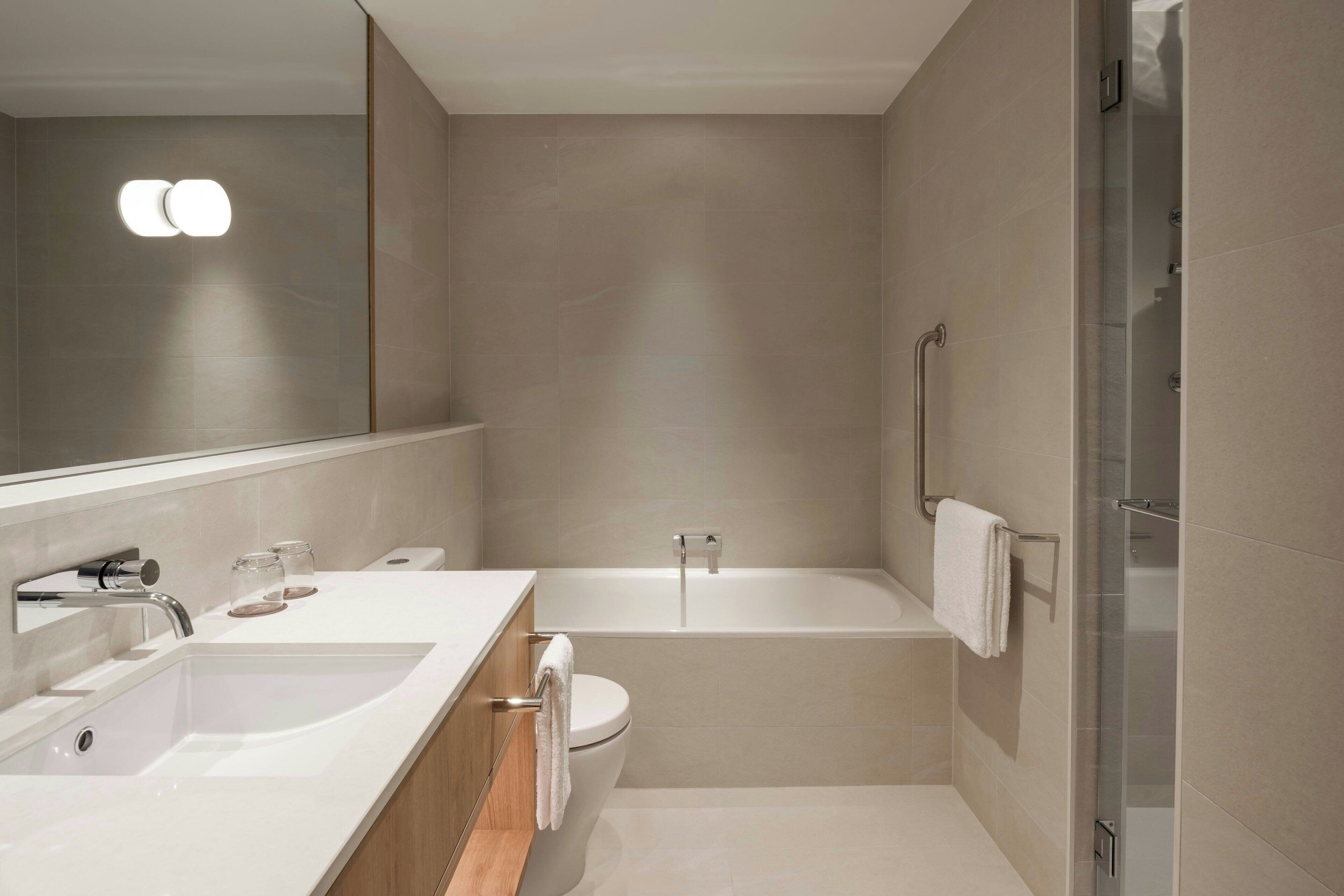 Ein modernes Badezimmer mit Waschbecken, Toilette und Badewanne.