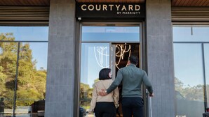 Una entrada moderna a un edificio con un letrero que dice "COURTYARD BY MARRIOTT".