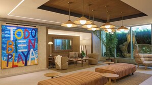 A modern living room with a large abstract painting, multiple seating areas, and a view of greenery outside. - Casa Costera, Isla Verde Beach, Apartments by Marriott Bonvoy (Carolina)