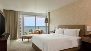 A hotel room with a large bed, a desk, a chair, a TV, and a view of the sea. - Casa Costera, Isla Verde Beach, Apartments by Marriott Bonvoy (Carolina)