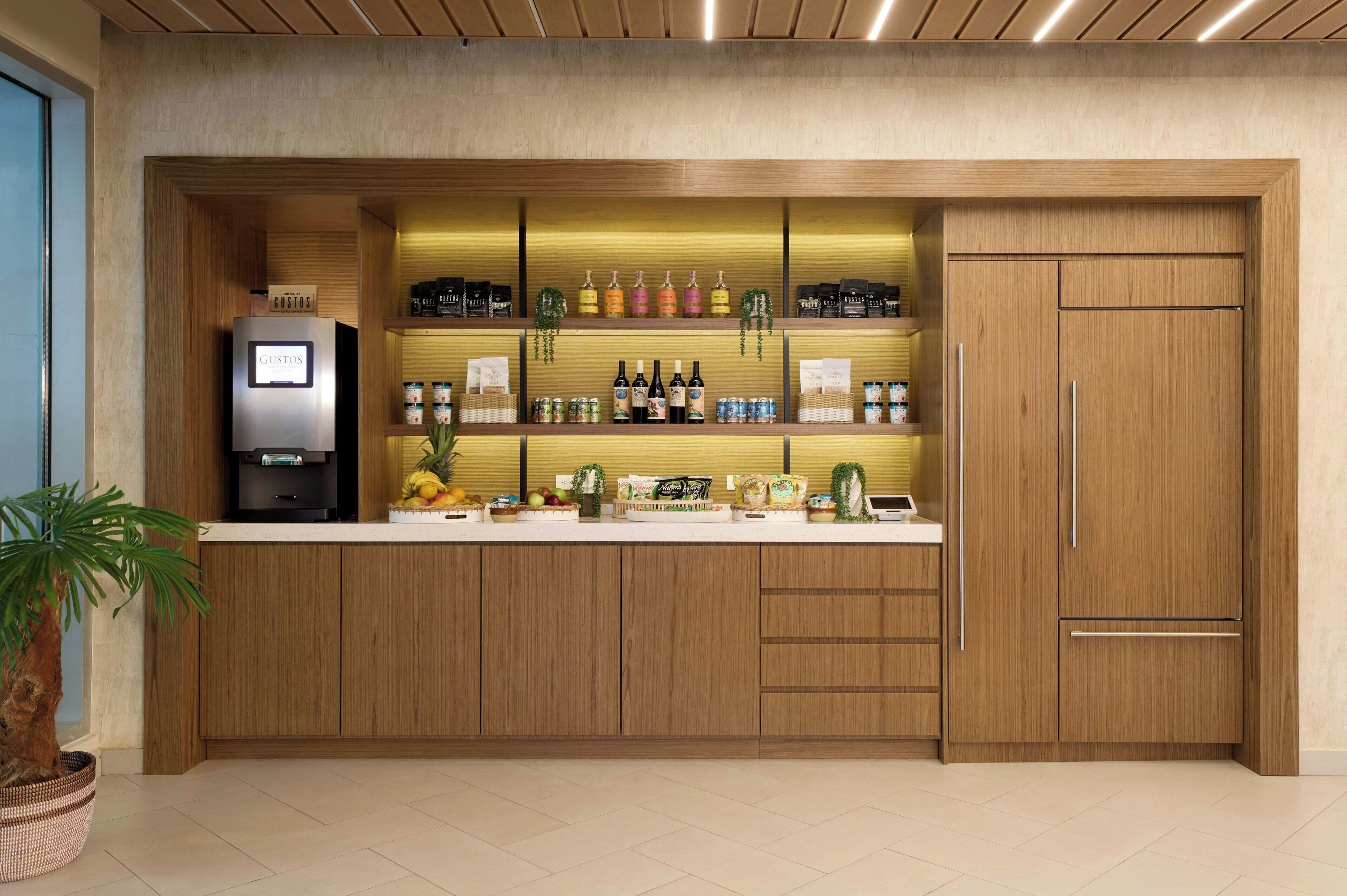 Une cuisine moderne avec des armoires en bois, un réfrigérateur encastré et divers produits alimentaires disposés sur le plan de travail.