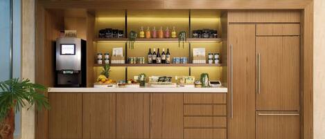 Une cuisine moderne avec des armoires en bois, un réfrigérateur encastré et divers produits alimentaires disposés sur le plan de travail.