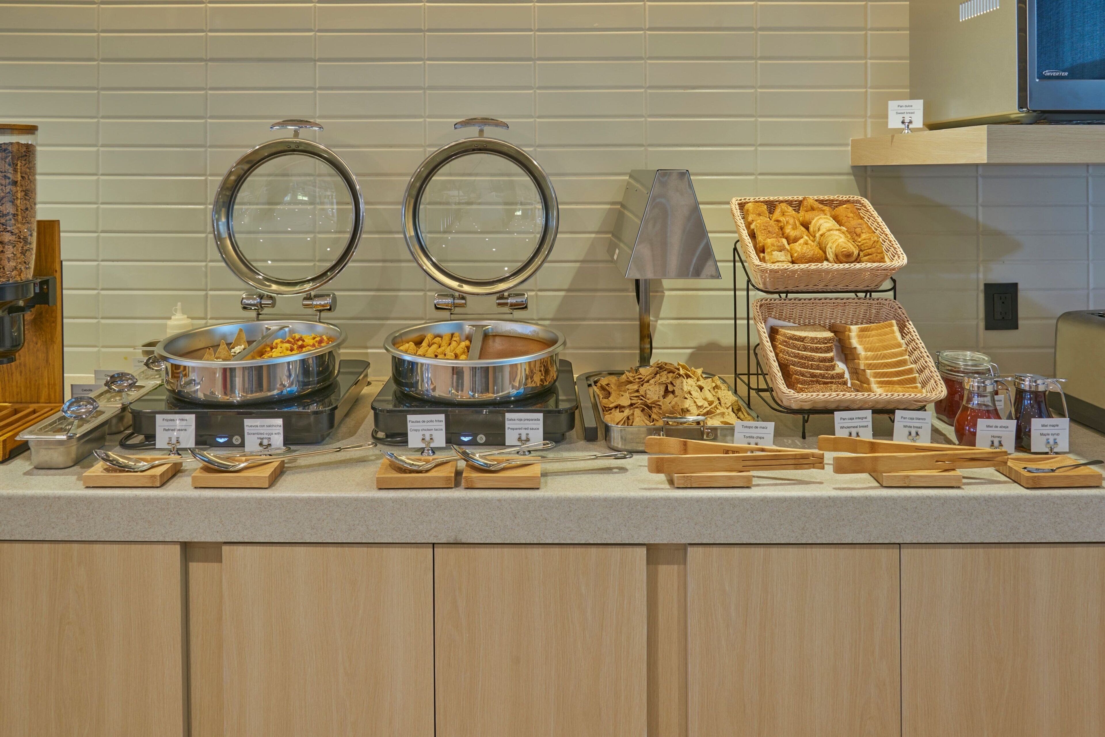 Una mesa de buffet con diferentes alimentos y utensilios de servir.