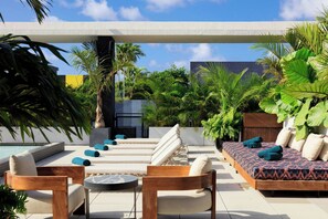 A rooftop terrace with a pool, lounge chairs, a wooden bench, and various plants. - Moxy Miami Wynwood (Miami)