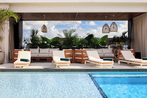 Una piscina al aire libre, camas de piscina gratis, sombrillas