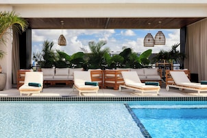 Una piscina al aire libre, camas de piscina gratis, sombrillas