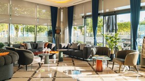 A modern hotel lobby with a large sofa set, a coffee table, and a potted plant.