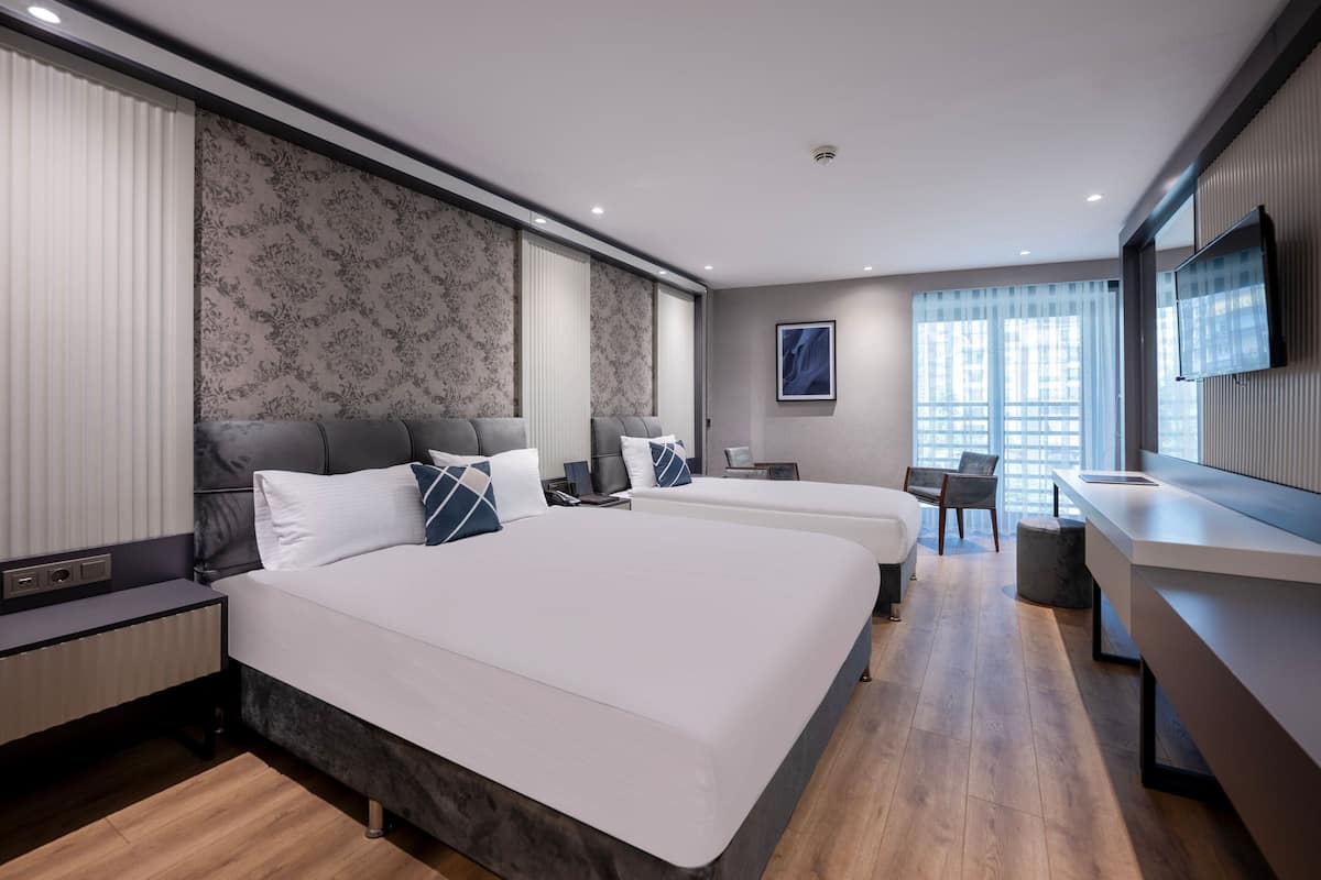 Une chambre d’hôtel moderne avec un grand lit, un bureau et une chaise.
