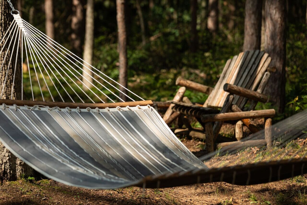 Embrace nature with a moment of relaxation in our hammock, surrounded by the tranquil beauty of the woods.