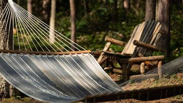 Embrace nature with a moment of relaxation in our hammock, surrounded by the tranquil beauty of the woods.