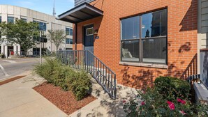 A red brick building with a metal railing and a window.