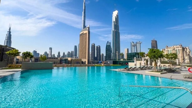 A swimming pool with a city skyline in the background. - Stylish 1BR with DIFC Skyline and Zabeel Views (Downtown)