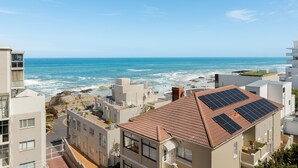 A coastal residential area with modern buildings, a rocky shoreline, and a view of the ocean. - Stunning Bantry Bay Haven - Beach on Your Doorstep (Cape Town)