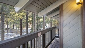 A wooden deck with a railing, overlooking a forested area. - Sunshine Village 126: Pet friendly, Close to Green (Mammoth Lakes)