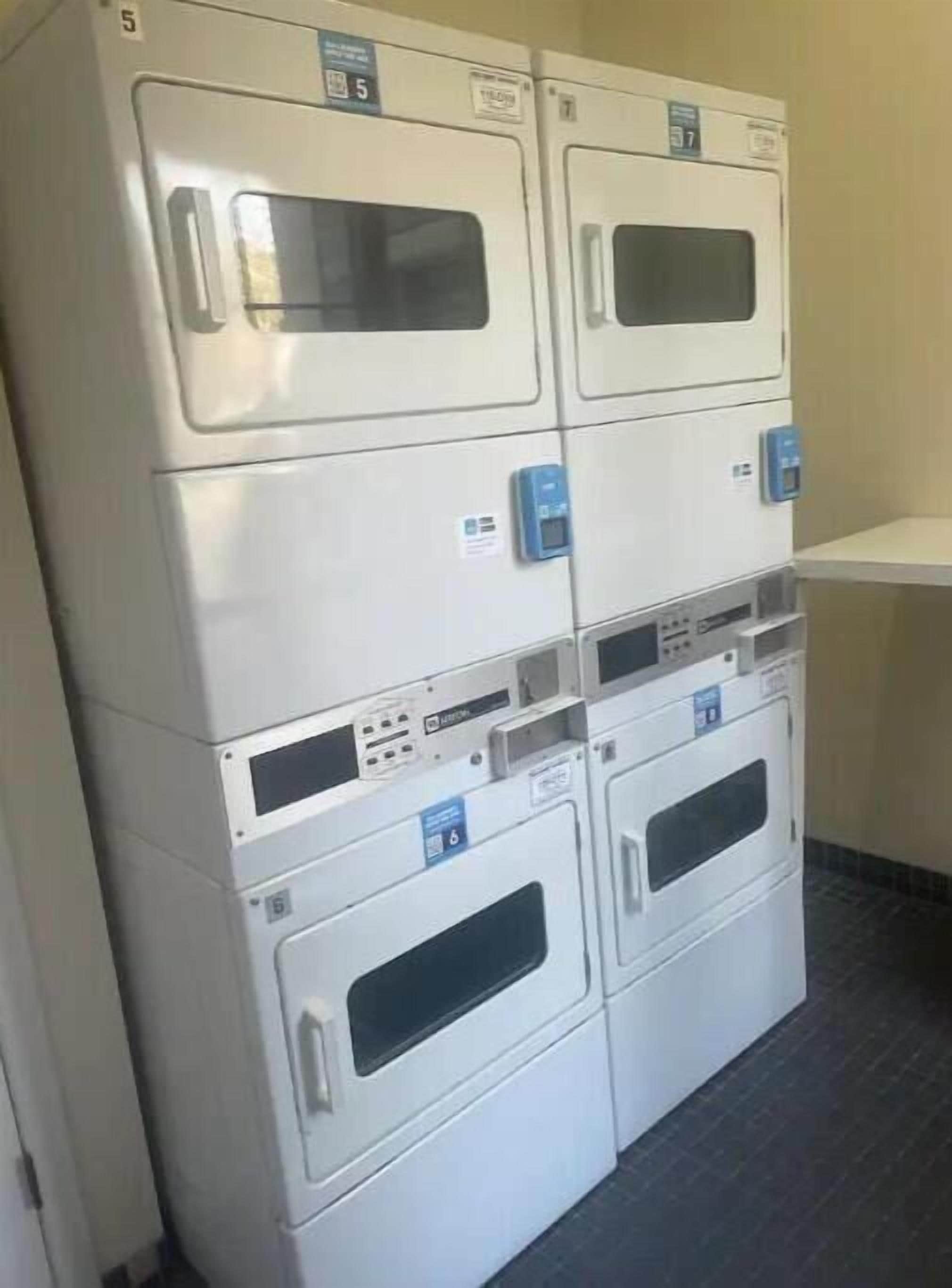 Une rangée de machines à laver empilées dans une pièce.