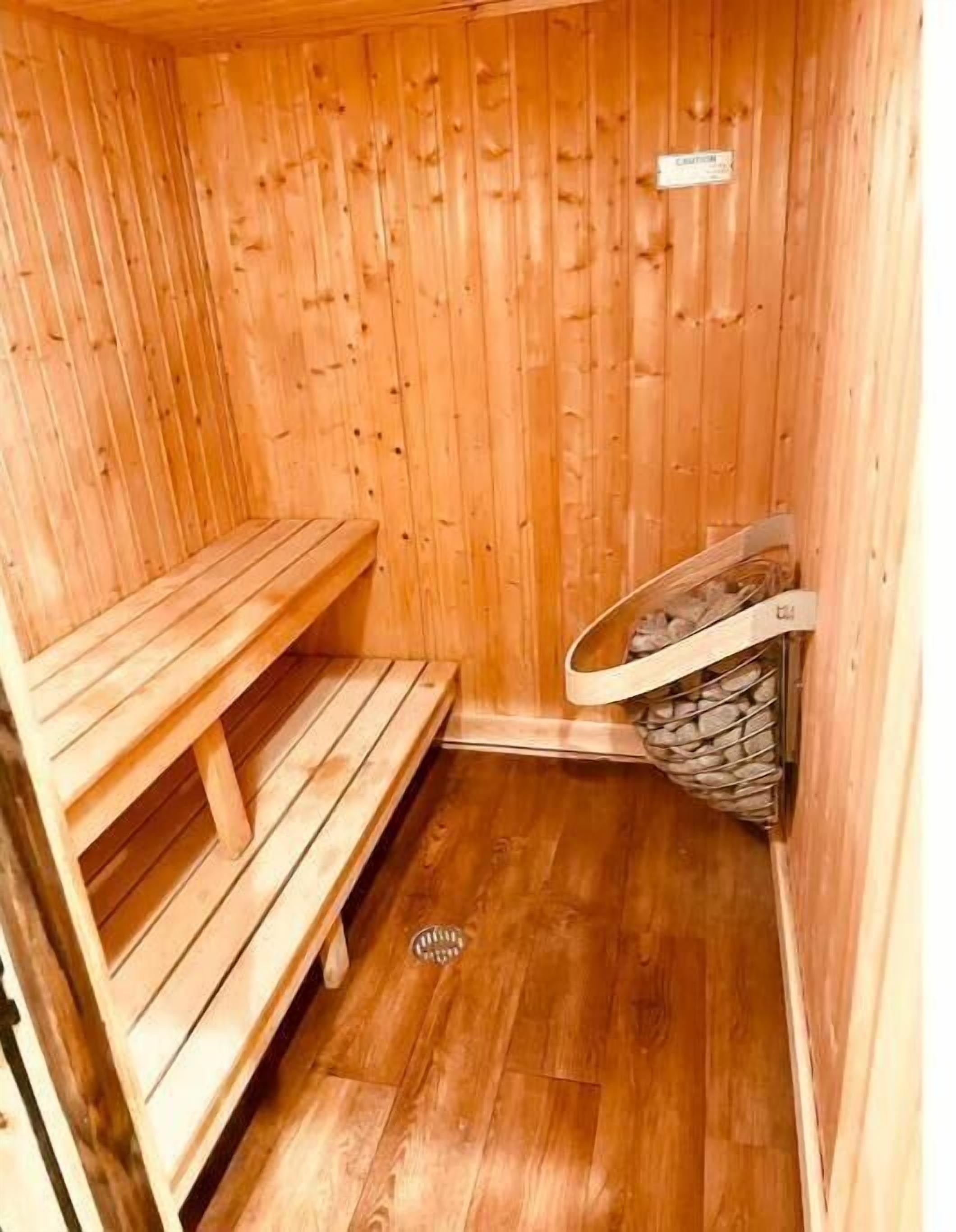 A wooden sauna with benches and a stone bench.